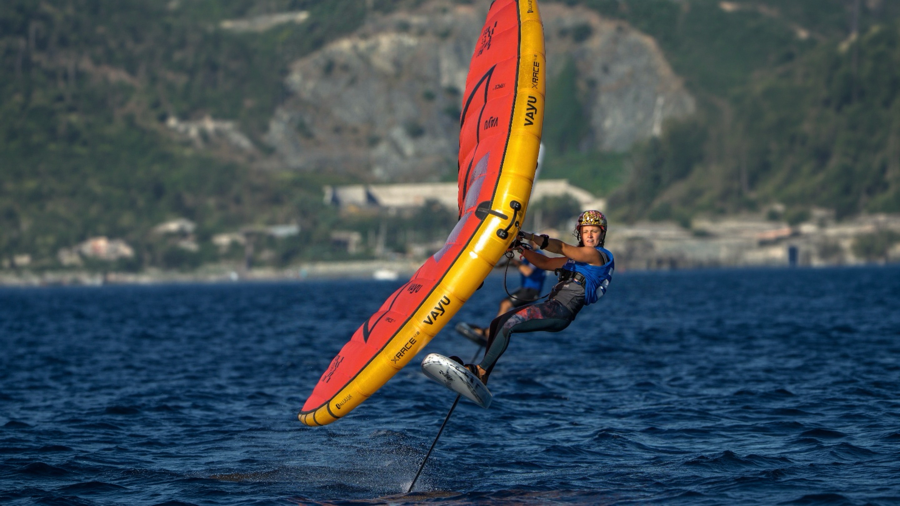 Marta Monge in volo sul foil con un'ala Vayu rossa e gialla